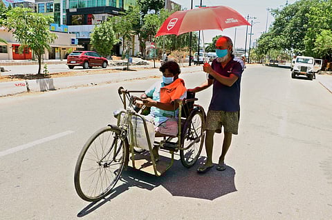 A physically handicapped person being helped by his friend to protect him from the heat in Bhubaneswar. (File Photo | Express)