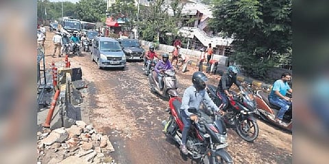Commuters pass after authorities cover the road with sand