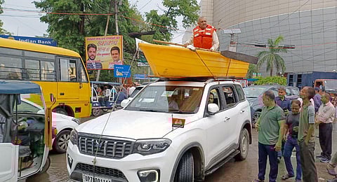 SP MLA Amitabh Bajpai sits in a boat that is placed on the roof of a car to protest against the problem of waterlogging in Kanpur. (Photo | ANI)