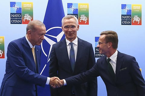 Turkey's President Recep Tayyip Erdogan shakes hands with Sweden's Prime Minister Ulf Kristersson as NATO Secretary General Jens Stoltenberg looks on ahead of the NATO summit (Photo | AP)