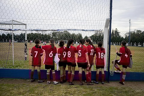 Candelaria Cabera, a 12-year-old player with the Huracan de Chabas female team, 11, wait for her team's soccer match against Alumni in Arequeito, Argentina, June 19 , 2023. (Photo | AP)