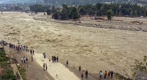 Locals walk along the eroded riverbank damaged by the swollen Beas river following heavy monsoon rains, in Kullu, Himachal Pradesh, Tuesday, July 11, 2023. (Photo |PTI)