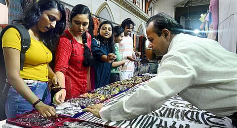 Customers trying fancy items at the Rajasthan Handloom and Handicraft Expo being held in Thiruvananthapuram. (Photo | Express)