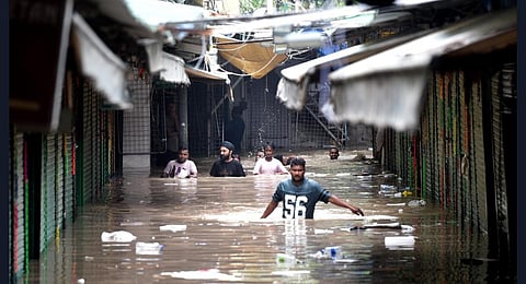 Locals at the flooded Monastery market following monsoon rains, in New Delhi on Wednesday.( Express photo by Shekhar Yadav)