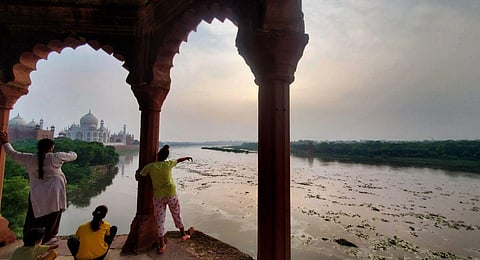 Locals watch swollen Yamuna river following monsoon rains, in Agra, Wednesday, July 12, 2023. (Photo | PTI)