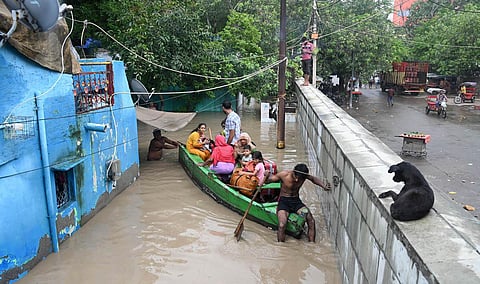 People from low-lying areas around the Yamuna river carry their belongings while relocating to a safer place, in New Delhi. (Photo | Shekhar Yadav, EPS)