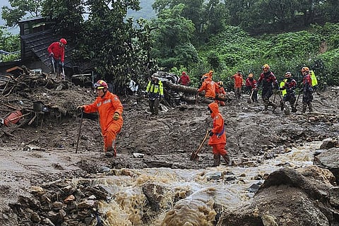 Rescue workers search for people in houses collapsed folowing a landslide caused by heavy rain in Yecheon, South Korea. (Photo | AP)