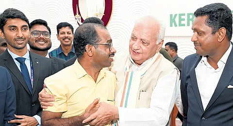 Governor Arif Mohammed Khan embraces Roopesh H when KAS batch members visited him at Raj Bhavan. (Photo | Express)