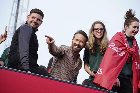FILE - Wrexham co-owner Ryan Reynolds, center, celebrates with members of the Wrexham FC soccer team the promotion to the Football League in Wrexham, Wales, on May 2, 2023. (Photo | AP)