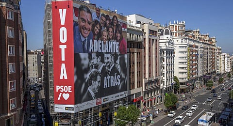 A poster depicting Spain's PM Pedro Sánchez and conservative PP party leader Alberto Feijóo and far-right VOX party leader Santiago Abascal is displayed on a building in Madrid. (Photo | AP)