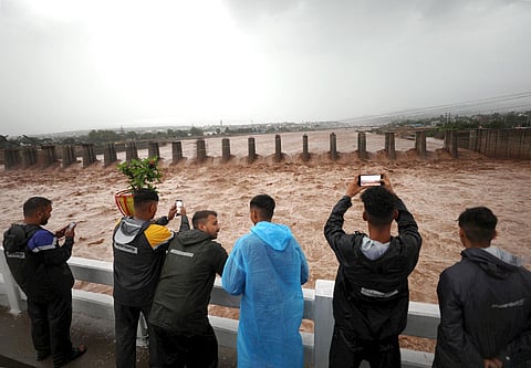 People watch the swollen Tawi river after heavy monsoon rains, in Jammu, Wednesday, July 19, 2023.(Photo|PTI)