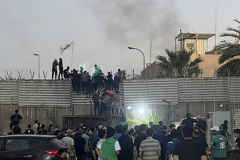 Protesters scale a wall at the Swedish Embassy in Baghdad Thursday, July 20, 2023. (Photo | AP)