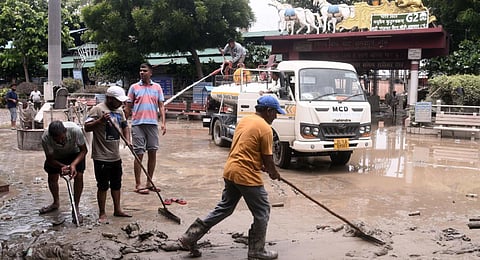 Workers clean the Nigam Bodh Ghat near ISBT after flood water receded, on July 19, 2023.(Photo | Express)