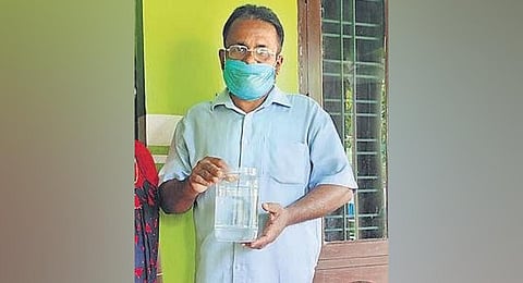Abraham A holding the jar containing Pathala Eel Loach. (Photo | Express)
