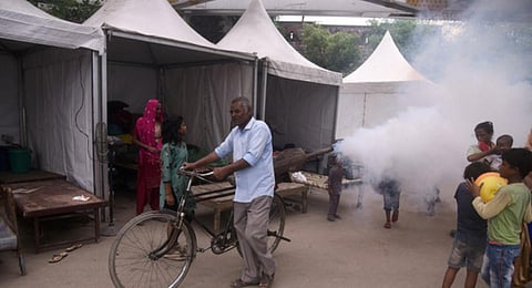 A Municipal Corporation of Delhi (MCD) worker fumigates the makeshift tents of flood victims to prevent the spread of Dengue and Malaria, Near Old Iron Bridge, in New Delhi.(Photo | Express)
