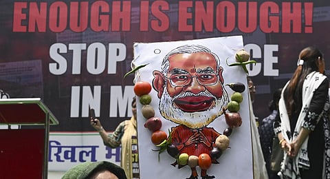A caricature of Prime Minister Narendra Modi on the backdrop of a Congress protest in New Delhi, over sexual violence against women in the ongoing ethnic violence in Manipur. (Photo | AFP)