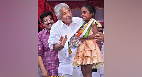 Chief Minister Oommen Chandy with Saranya, a Thalolam scheme beneficiary, after inaugurating the Hunger-free City project. (Photo | Express)