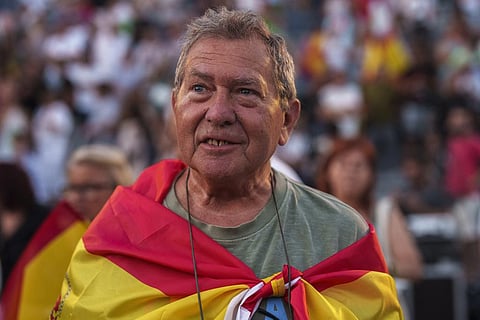 A supporter of VOX far right party wrapped in a Spanish flag attends an election campaign event in Guadalajara, Spain. (Photo | AP)