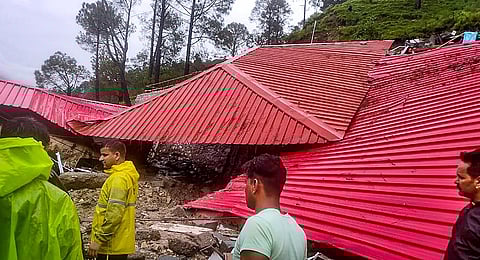 SDRF personnel and locals near a damaged property after heavy monsoon rains, in Uttarkashi district. (Photo | PTI)