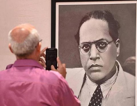 Representational image of a man clicking a photo of BR Ambedkar's portrait. (File photo | PTI)