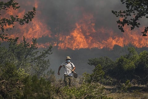 Flames burn a forest in Vati village, on the Aegean Sea island of Rhodes, southeastern Greece