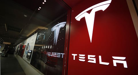 A sign bearing the Tesla company logo is displayed outside a Tesla store in Cherry Creek Mall in Denver. (Photo | AP)
