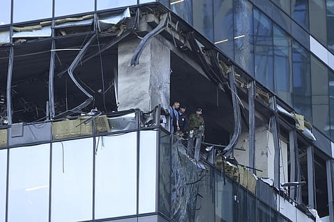 Investigators examine a damaged skyscraper in the 'Moscow City' business district after a reported drone attack in Moscow. (Photo | AP)