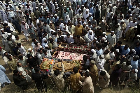Relatives and mourners gather around the caskets of victims who were killed in Sunday's suicide bomber attack in the Bajur district of Khyber Pakhtunkhwa, Pakistan. (Photo | AP)