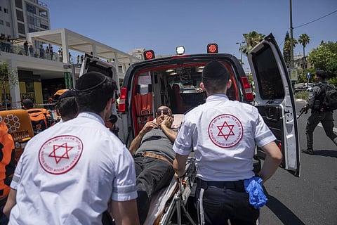 Israeli paramedics evacuate an injured man at the site of a Palestinian car-ramming attack at a bus stop in Tel Aviv, Israel, Tuesday, July 4, 2023. (Photo | AP)