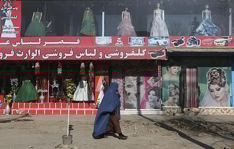 FILE - A woman walks past a beauty salon and dress shop in Kabul, Afghanistan. (Photo | AP)