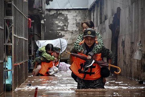 Members of the Chinese People's Armed Police Force evacuate flood trapped residents in Wanzhou District, in southwest China's Chongqing Municipality.(Photo | AP)