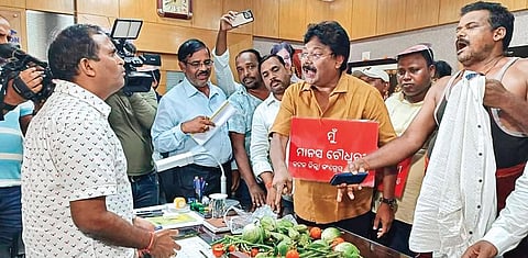 Choudhury along with the Congress party members offering vegetables to the executive engineer I EXPRESS