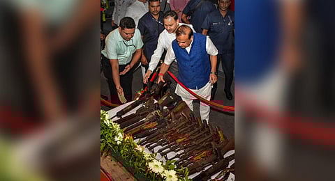 Assam Chief Minister Himanata Biswa Sarma looks at arms which were laid down by five tribal militants group during a ceremony, in Guwahati. (Photo | PTI)