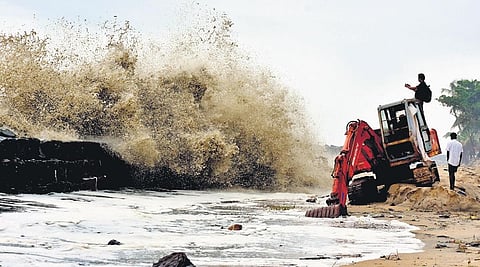 A resident captures a video of lashing sea waves, standing on an unused earthmover at Njarakkal on Wednesday | A Sanesh