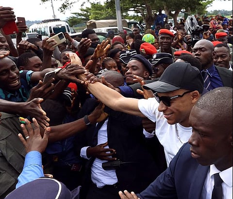 Kylian Mbappe greets crowds gathered outside at the Yaounde Airport in Cameroon. (Photo |AFP)