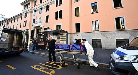 Members of the police evacuate the body of a victim after a fire killed six people at a retirement home in Milan. (Photo | AFP)