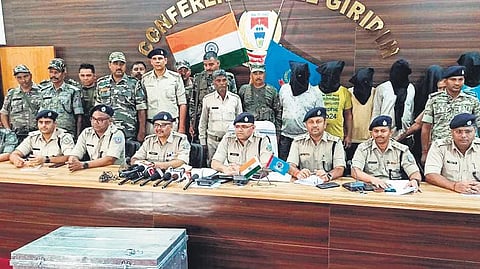 Giridih district police officials with the accused persons and the cash notes retrieved during a press conference | Express
