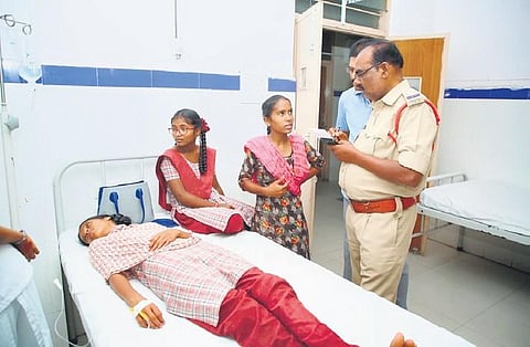 A police official conducts an inquiry after 50 students from Kasturba Gandhi Balika Vidyalaya (KGBV) in Amarchinta fell sick after having dinner on Thursday night