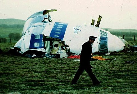 A police officer walks by the nose of Pan Am flight 103 in a field near the town of Lockerbie, Scotland where it lay after a bomb aboard exploded, killing 270 people, December 21, 1988. (AP)