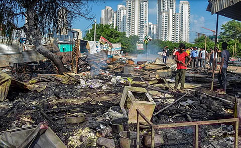A worker inspects burnt items at a shop which was set ablaze by miscreants in a fresh case of communal violence after Monday's attack on a VHP procession in adjoining Nuh district. | PTI