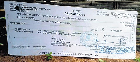 A cut-out of the cheque given by Governor Tamilisai Soundararajan to the Chenchus on March 23, 2023, lying in front of a hut in Appapur gram panchayat