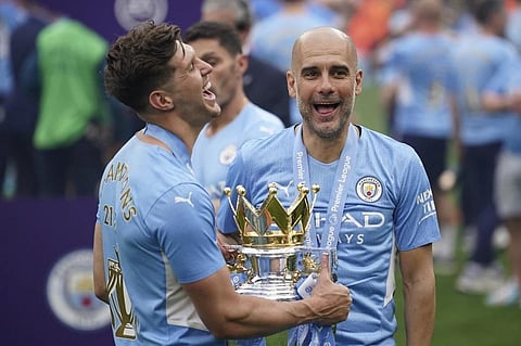Manchester City's head coach Pep Guardiola, right, smiles with trophy after winning the 2022 English Premier League title. (File Photo | AP)