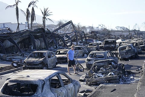 A man walks through wildfire wreckage Friday, Aug. 11, 2023, in Lahaina, Hawaii. (Photo | AP)