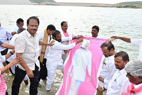 Excise Minister V Srinivas Goud and other BRS leaders perform ‘milk abhishekam’ to Chief Minister K Chandrasekhar Rao’s portrait at Karivena reservoir on Friday. (Photo | Express)