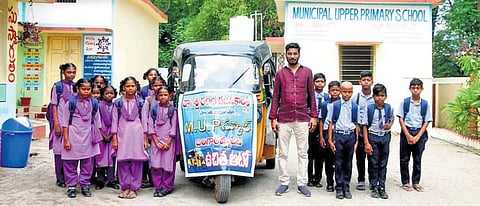 Headmaster Rambha Rajinikanth along with the students at the government municipal upper primary school in Saluru I express