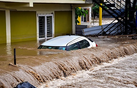 A car stuck in the flood water near a resort due to rise in the water leave of Maldevta river owing to relentless rains, in Dehradun (Photo | PTI)