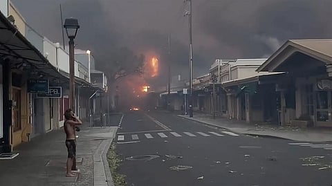 People watch as smoke and flames fill the air from raging wildfires on Front Street in downtown Lahaina, Maui on Tuesday, Aug. 8, 2023. (Photo | AP)