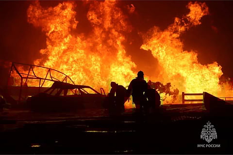 This handout photograph taken and released by Russian Emergency Ministry on August 14, 2023, shows rescuers pushing out a fire at a gas station in the city of Makhachkala. (Photo | AFP)