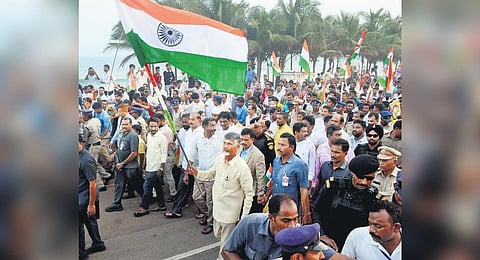Holding the national flag, TDP chief Nara Chandrababu Naidu takes part in a rally on Beach Road in Visakhapatnam on Tuesday I G Satyanarayana