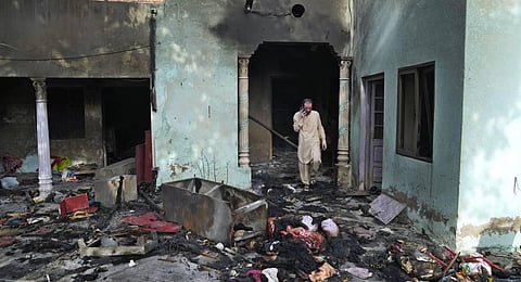 A Christian man looks at a home vandalized by an angry Muslim mob in Jaranwala in the Faisalabad district, Pakistan. (Photo | AP)